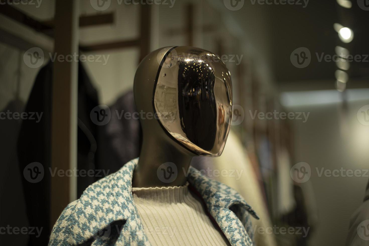 goldene Maske im Gesicht. Schaufensterpuppe im Bekleidungsgeschäft. Person ohne Gesicht. foto