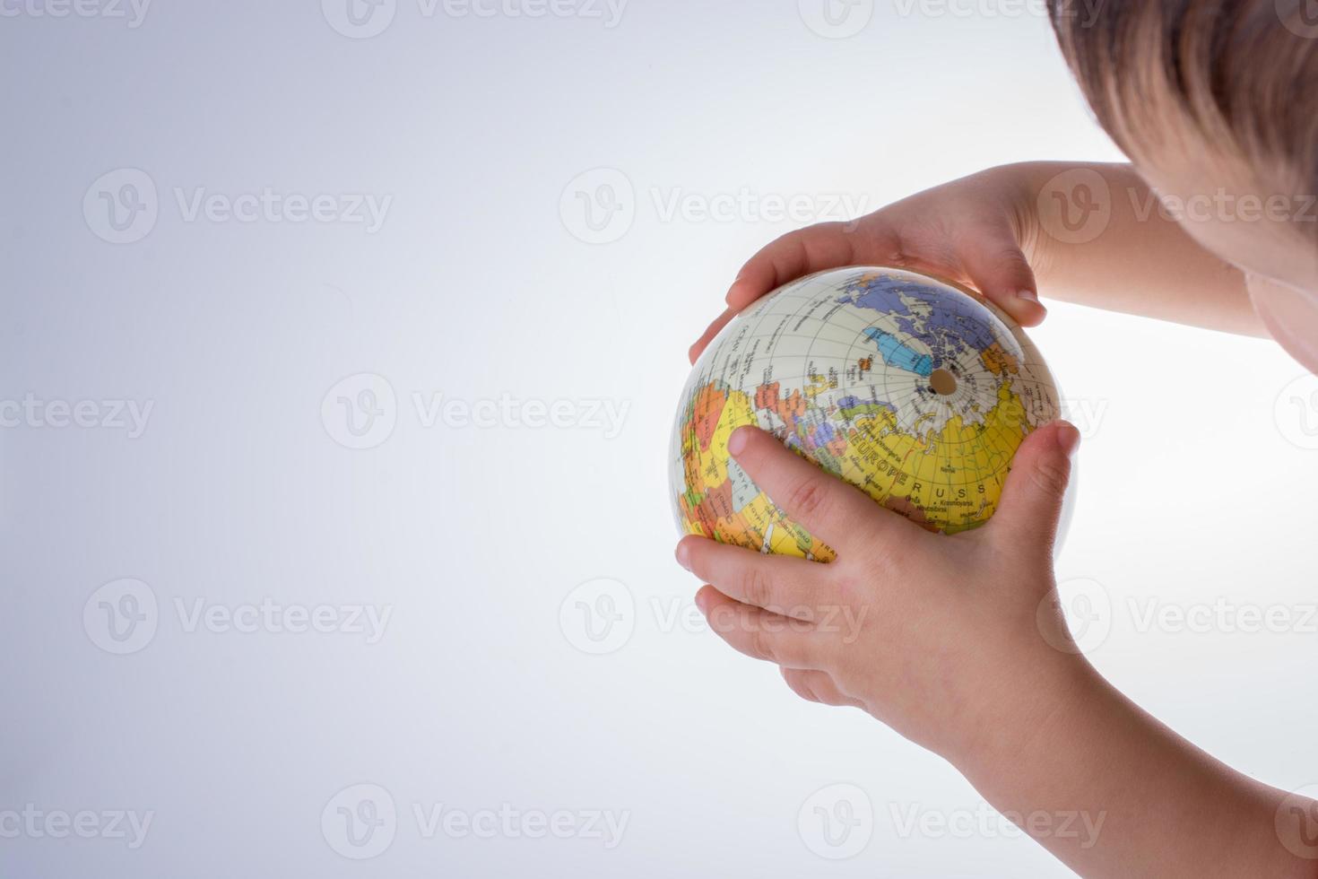 Kind, das einen Globus in der Hand hält foto