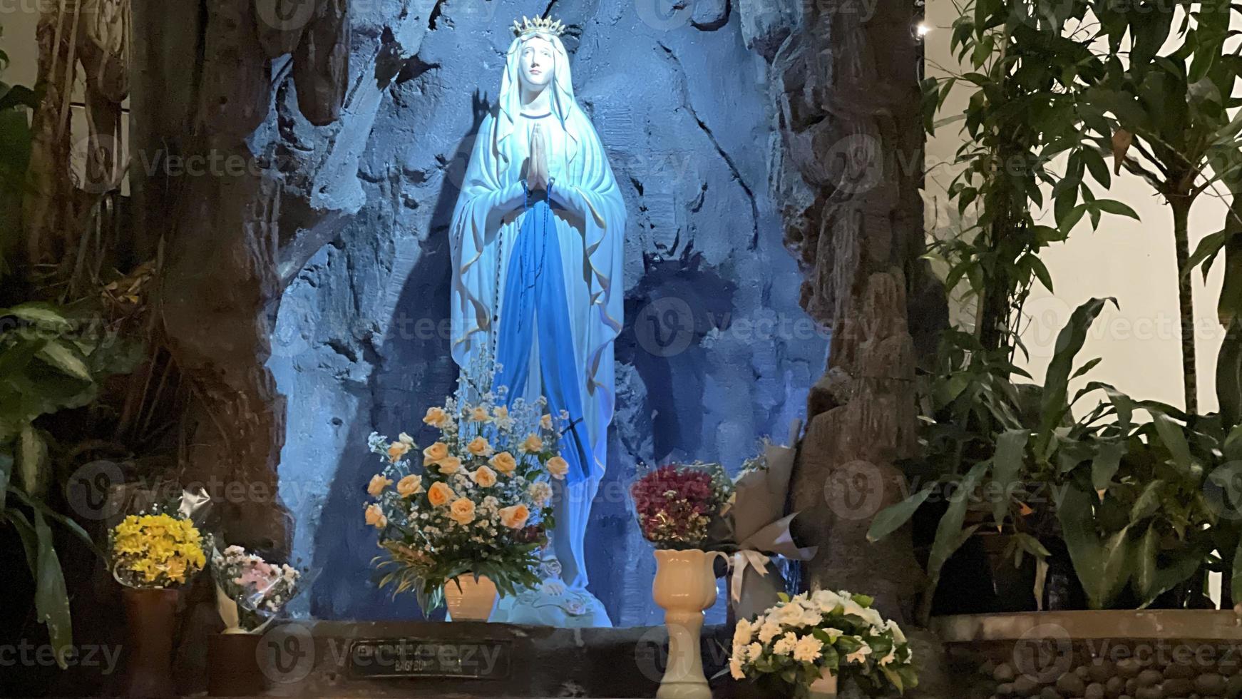 die höhle der jungfrau maria, statue der jungfrau maria in einer felshöhle kapelle katholische kirche mit tropischer vegetation foto