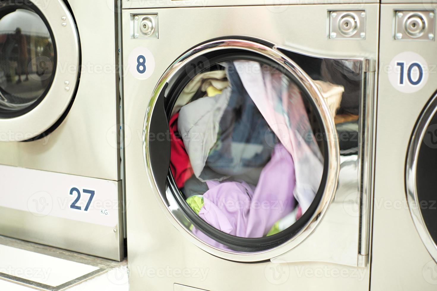 Nahbewegung verschwommen von der Kleidung, die sich in der Trockenmaschine im Waschsalon dreht foto