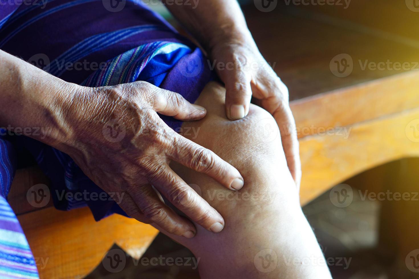 Nahaufnahme Die Hände einer älteren Frau massieren ihr schmerzhaftes Knie. konzept, gesundheitliche probleme. Knieverletzung, Arthrose. überlappender Knochen. foto