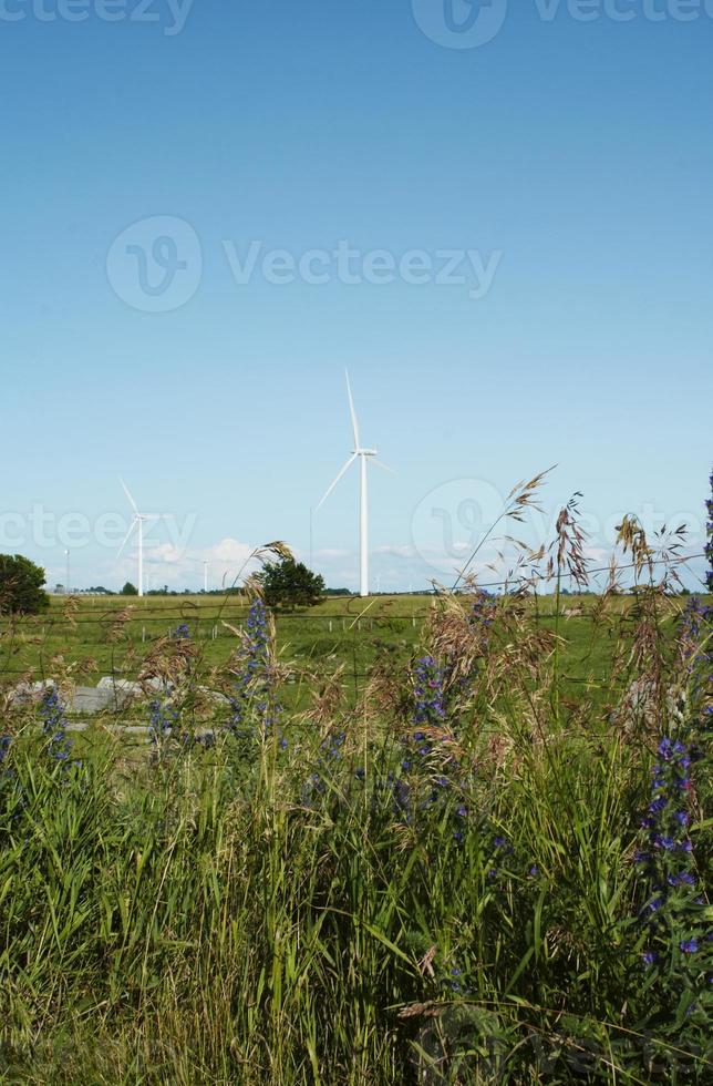 Windmühlen stehen vor einem blauen bewölkten Himmel foto