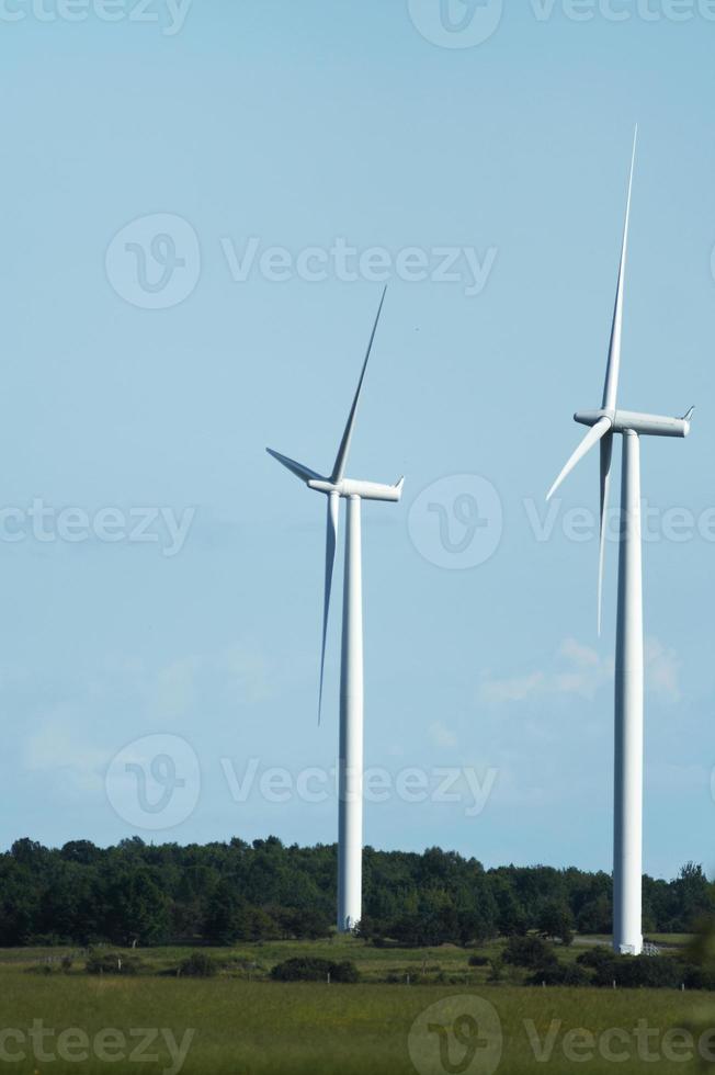 Windmühlen stehen vor einem blauen bewölkten Himmel foto