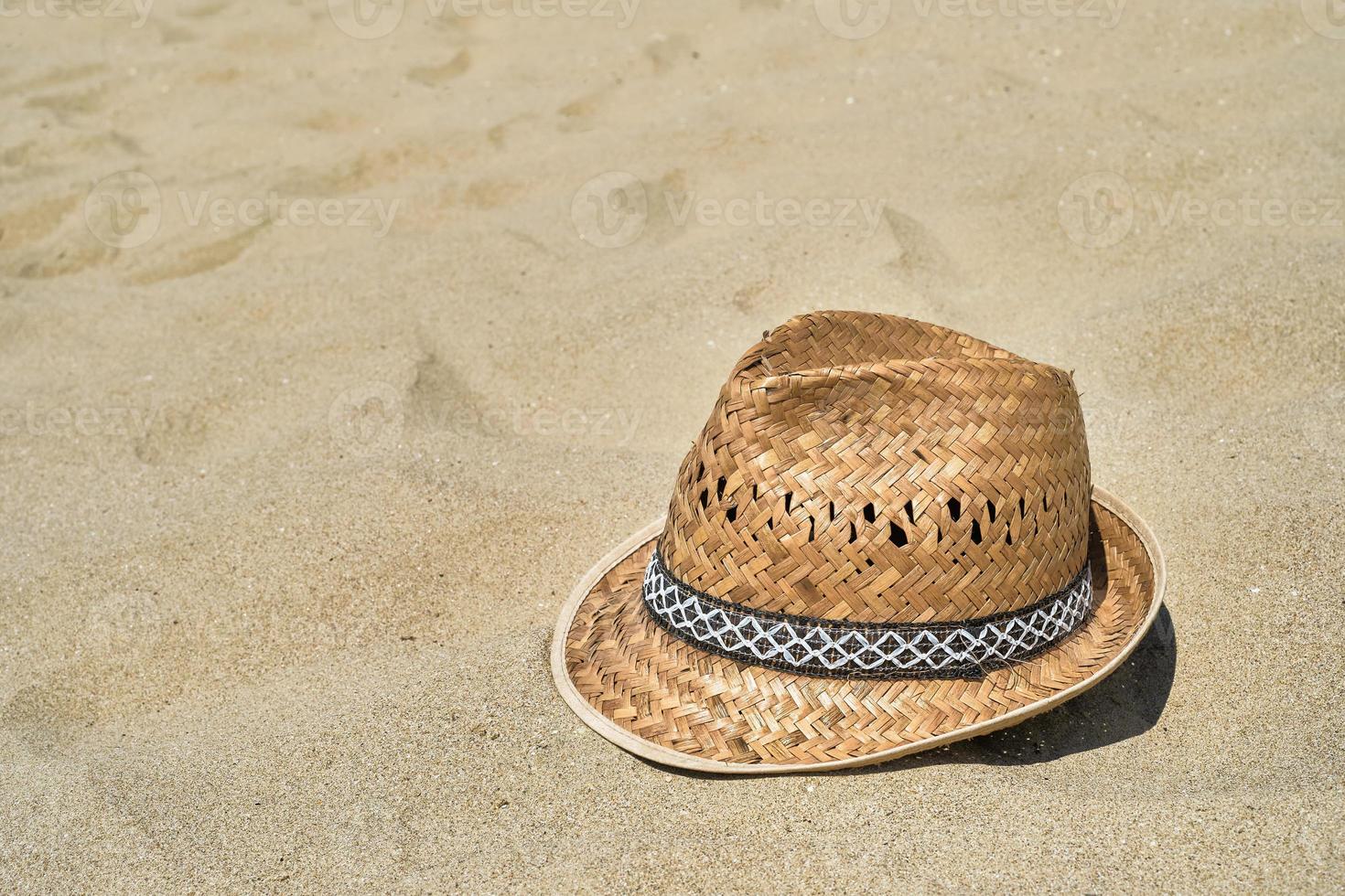 Strandhut aus Stroh für Herren auf dem Sand am Strand, Nahaufnahme, Platz für Text kopieren. ein schöner sonniger Tag. Urlaub, Sommerkonzept foto