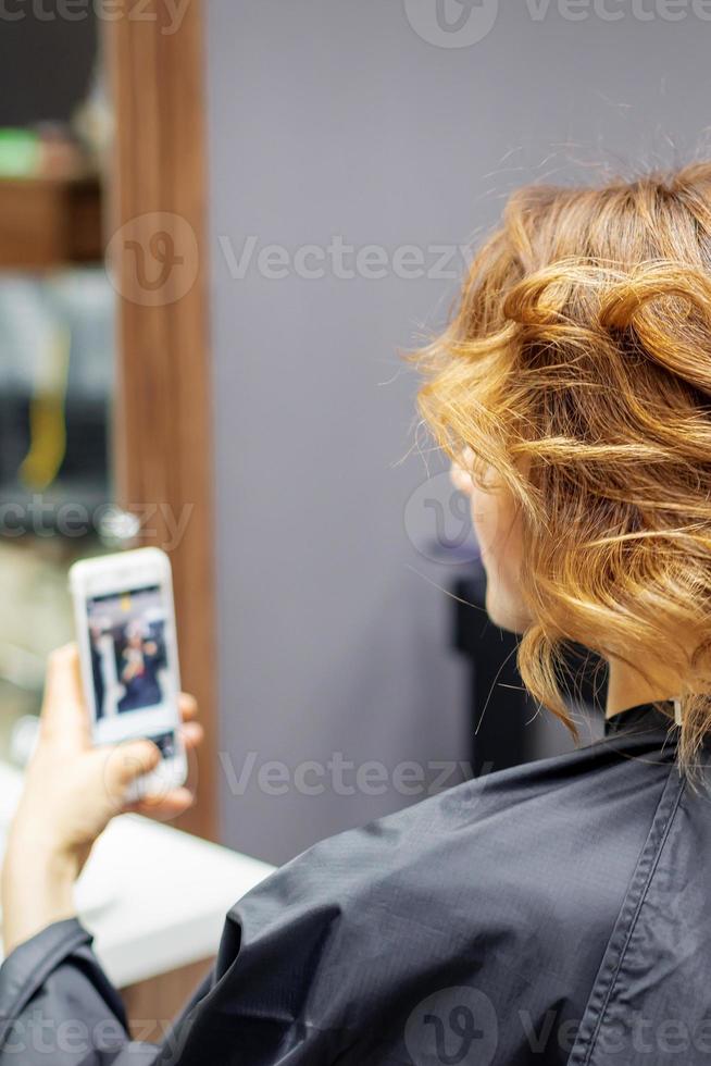 friseur, der frisur für junge frau macht foto