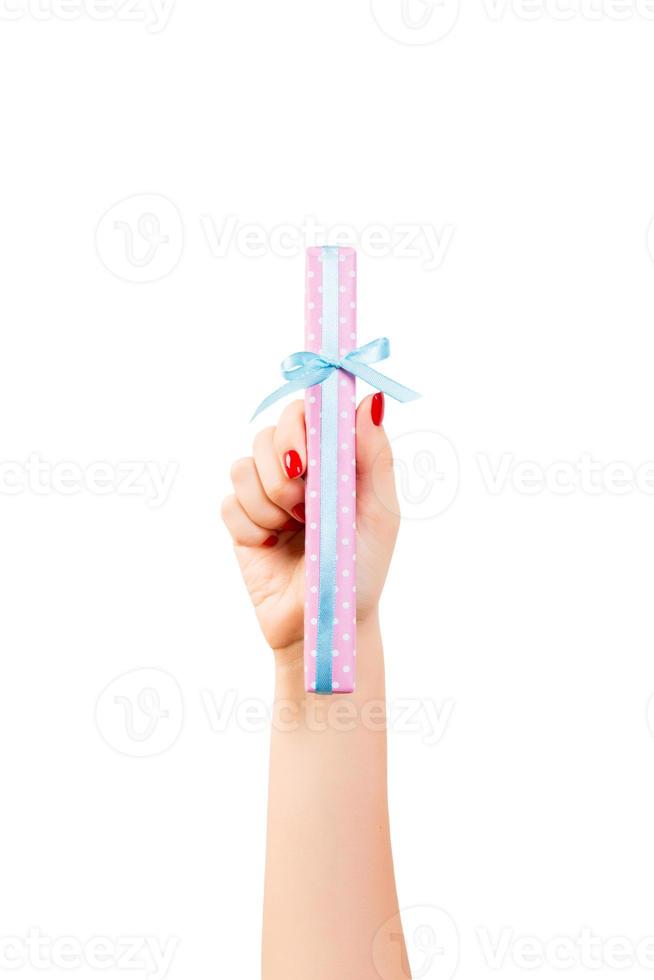 frauenhände geben eingewickeltes weihnachts- oder anderes handgemachtes geschenk in rosa papier mit blauem band. isoliert auf weißem Hintergrund, Ansicht von oben. Thanksgiving-Geschenkbox-Konzept foto