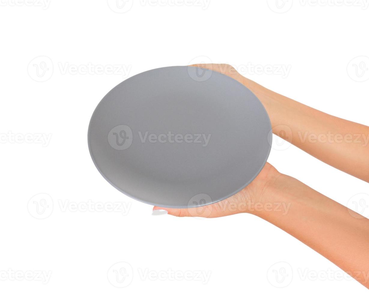 leere leere runde graue matte platte in weiblicher hand. perspektivische Ansicht, isoliert auf weißem Hintergrund foto