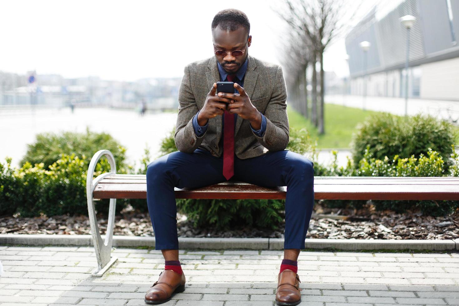 Afroamerikaner Geschäftsmann arbeitet in seinem Smartphone foto