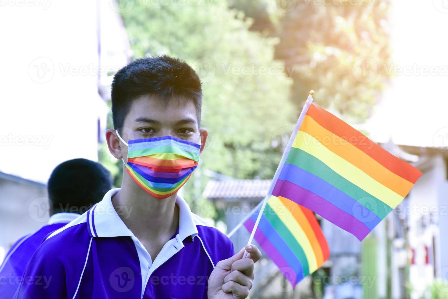 porträt asiatischer kleiner junge hält regenbogenfahne, lgbt-symbol, in den händen, während er sich seiner lgbt-aktivität in der schule anschließt, konzept für die lgbt-gemeinschaftsfeier im stolzmonat, juni 2023, auf der ganzen welt. foto