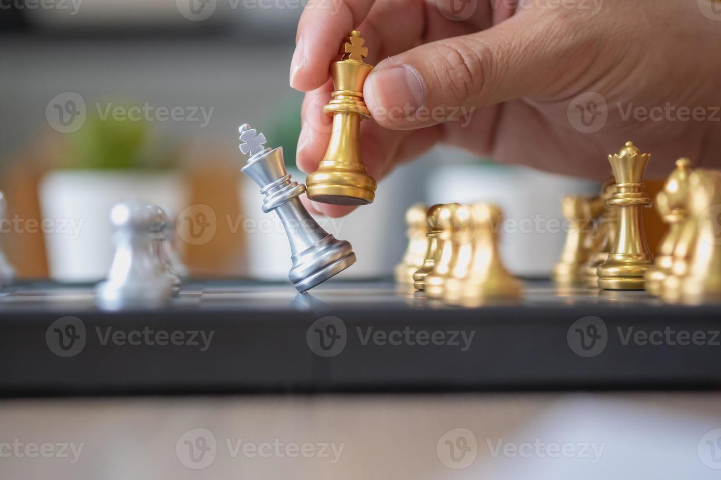 Das Unternehmen ist ein Geschäftsmann, dessen Hände Schach auf dem Spielplan bewegen, um das Geschäft auf dem Markt zu gewinnen. Konzept der Führung foto