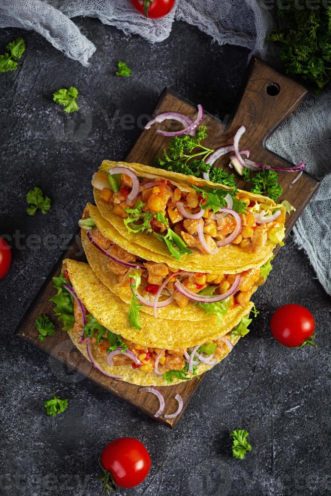 mexikanische Tacos mit Maistortilla. Tortilla mit Hühnerfleisch, Mais, Salat und Zwiebeln. Ansicht von oben foto