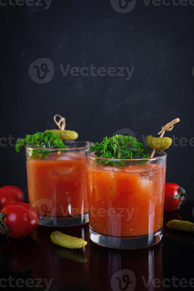 Alkoholcocktail Bloody Mary auf dunklem Hintergrund. Klassischer Cocktail mit Tomatensaft und Wodka foto