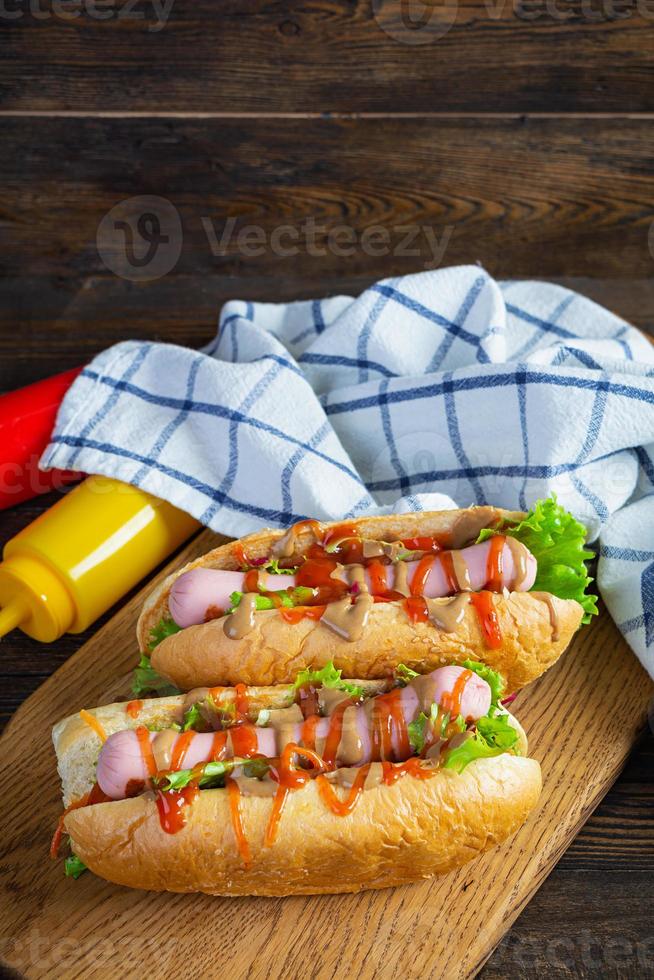 Köstlicher Hot Dog mit Ketchup und Senf auf Holzhintergrund. Straßenessen foto