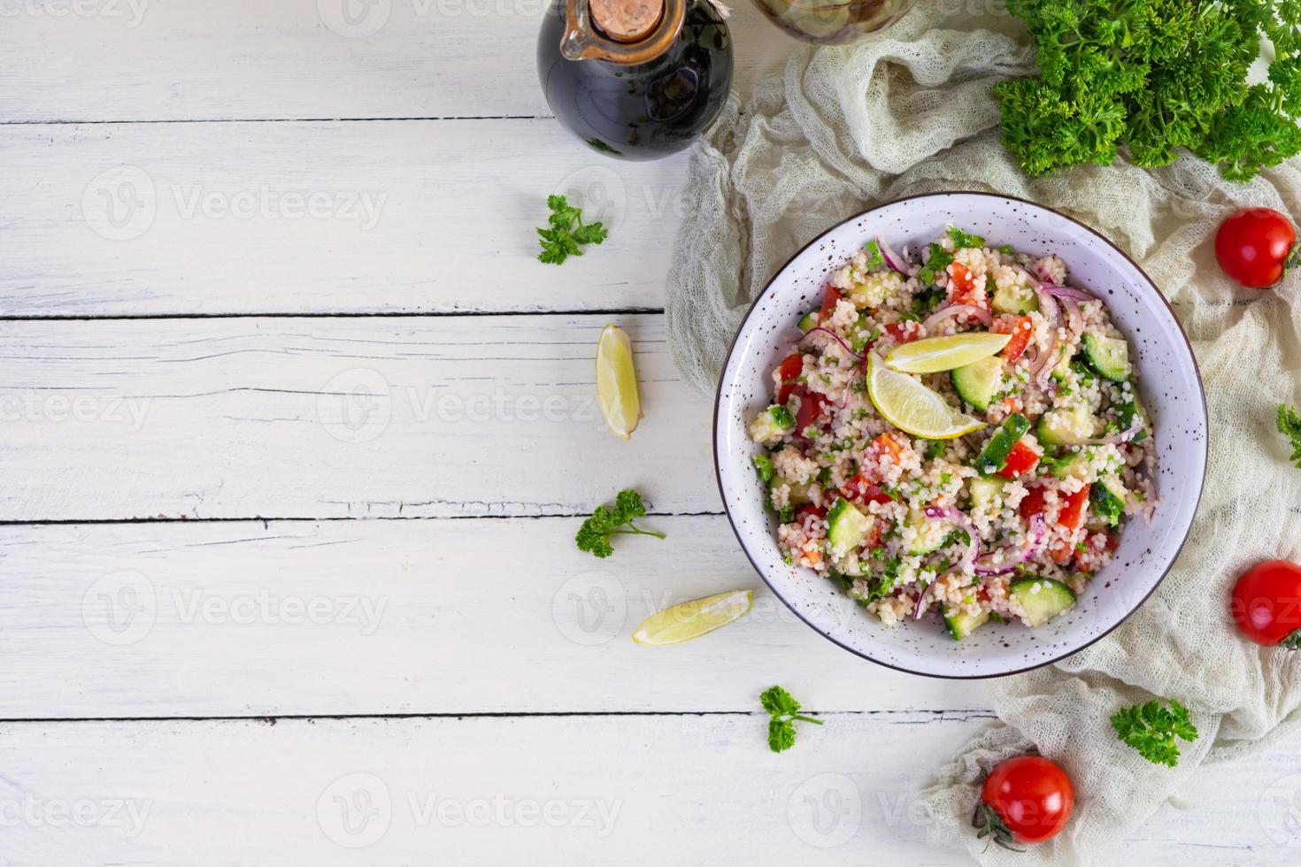 vegetarischer tabbouleh-salat mit couscous, petersilie, gurke, tomate. traditionelle nahöstliche oder arabische Küche foto