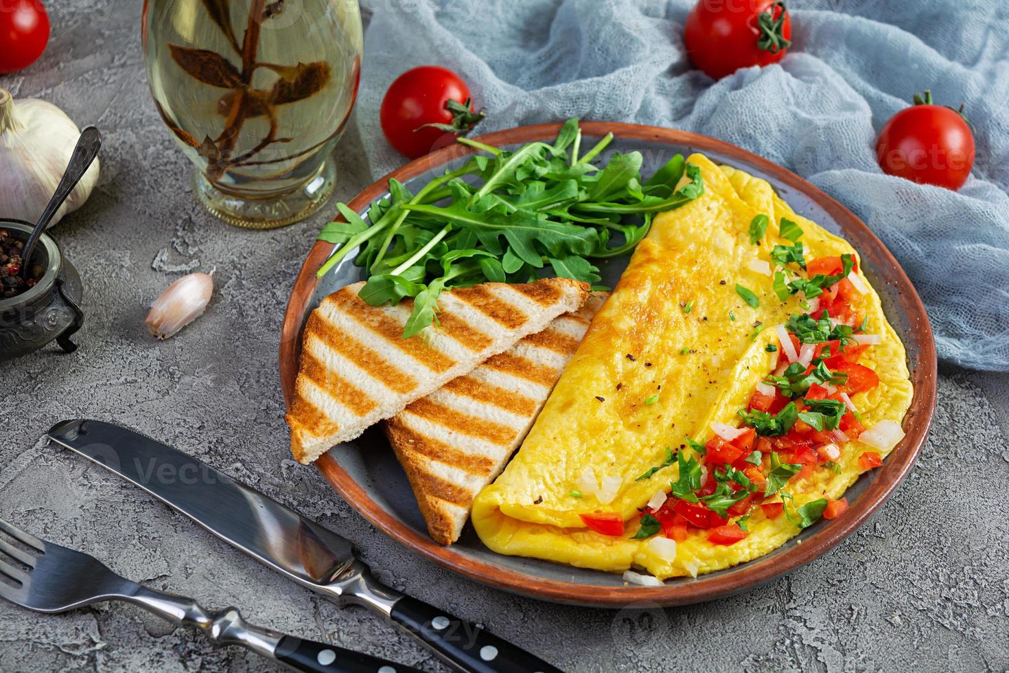gebratenes Omelett mit Tomaten, Zwiebeln und Kräutern. leckeres Frühstück mit Eiern und Toast foto