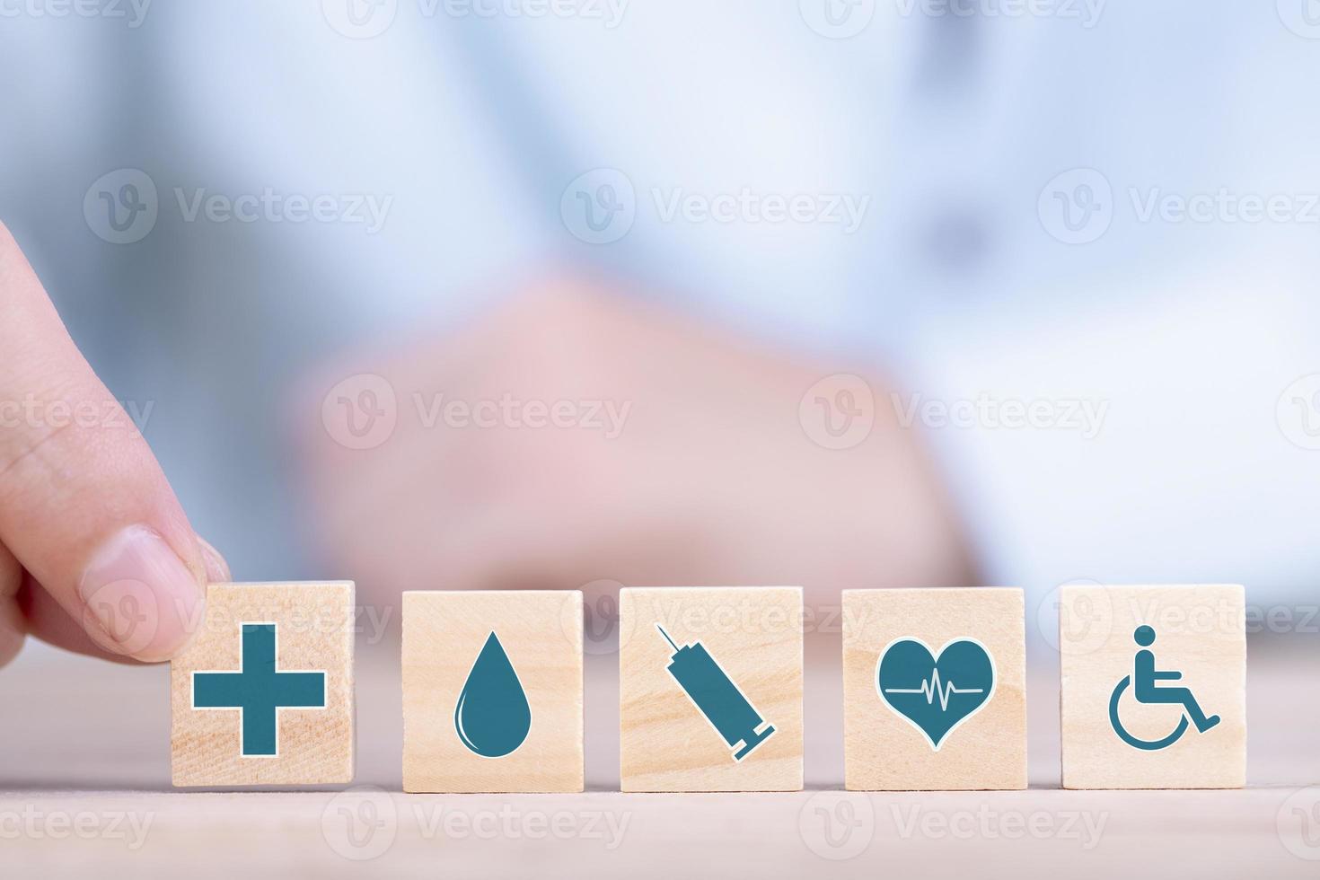 geschäftsmann wählt ein emoticon-ikonen-gesundheitswesen-medizinisches symbol auf holzblock-, gesundheits- und krankenversicherungskonzept foto