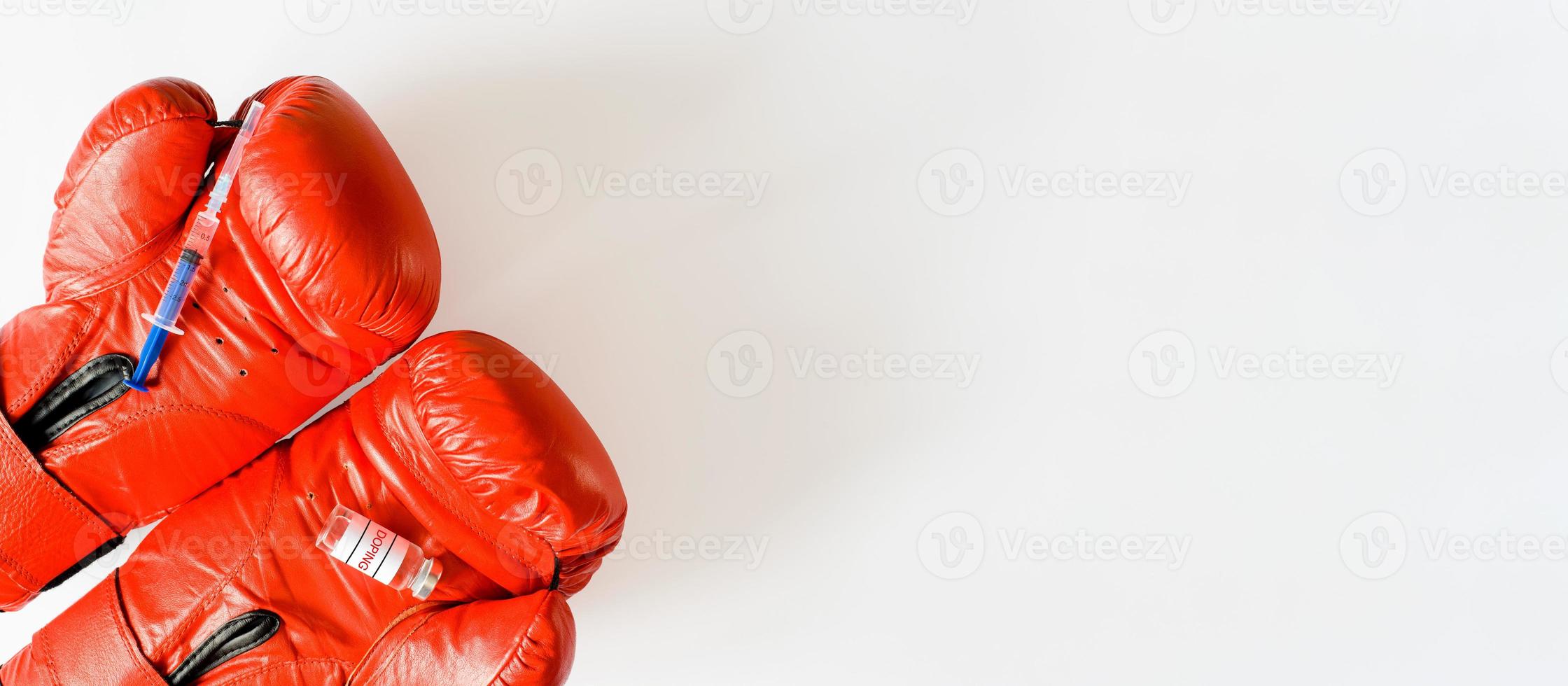 Spritze und Schmierampulle auf roten Boxhandschuhen. Banner, Kopierbereich. doping, pharmakologie und sportkonzept. foto