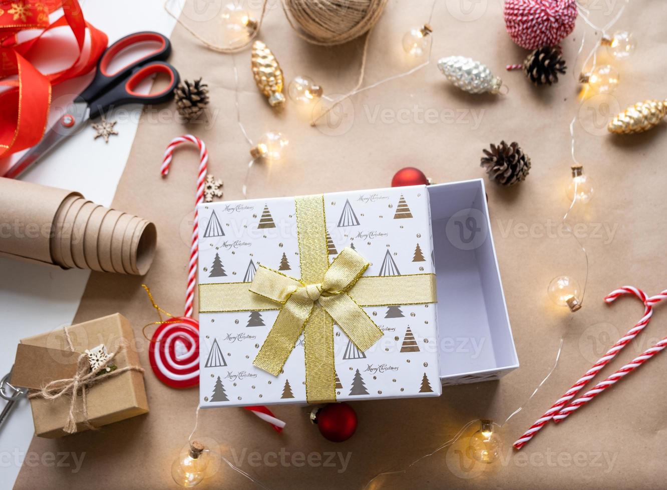 verpacken sie ein geschenk für weihnachten und neujahr in kraftpapier, kegeln, klebeband, schere. tags mit mock-up, natürliches dekor, handgemacht, diy. Festliche Stimmung. Flatlay, Hintergrund foto