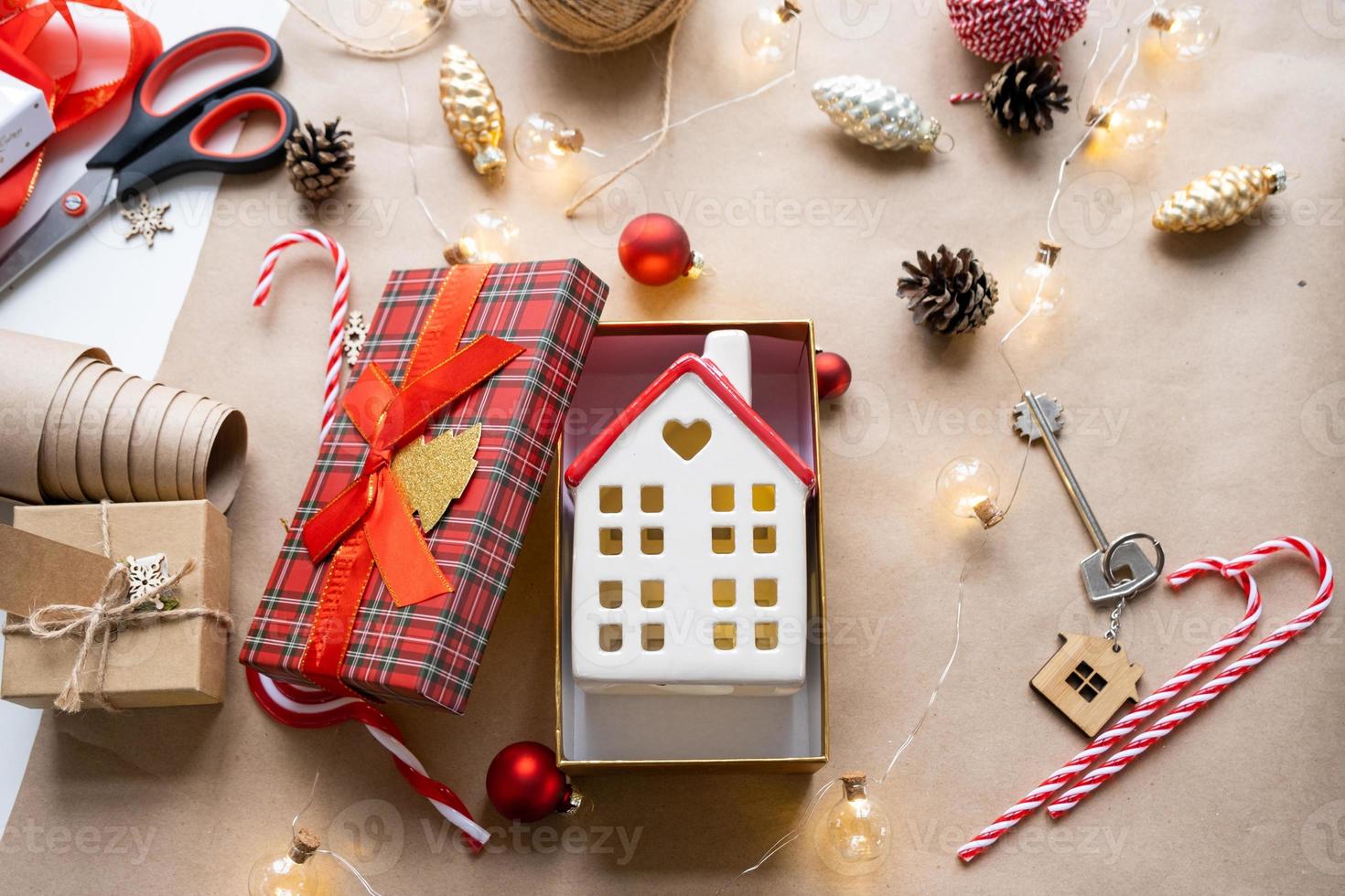 schlüssel zum haus mit schlüsselbund auf gemütlichem zuhause in geschenkbox mit weihnachtsdekorverpackung. pack geschenk für neujahr, weihnachten. Bauen, Projekt, Umzug in ein neues Haus, Hypothek, Miete, Kauf von Immobilien foto