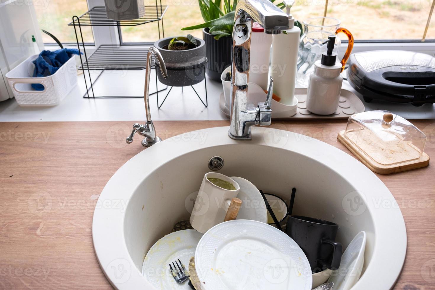 Schmutziges Geschirr in der Spüle in der Küche, Chaos nach dem Mittagessen, zu faul zum Geschirrspülen. Küchenreinigung, Waschmittel, Reinigungsdienste foto