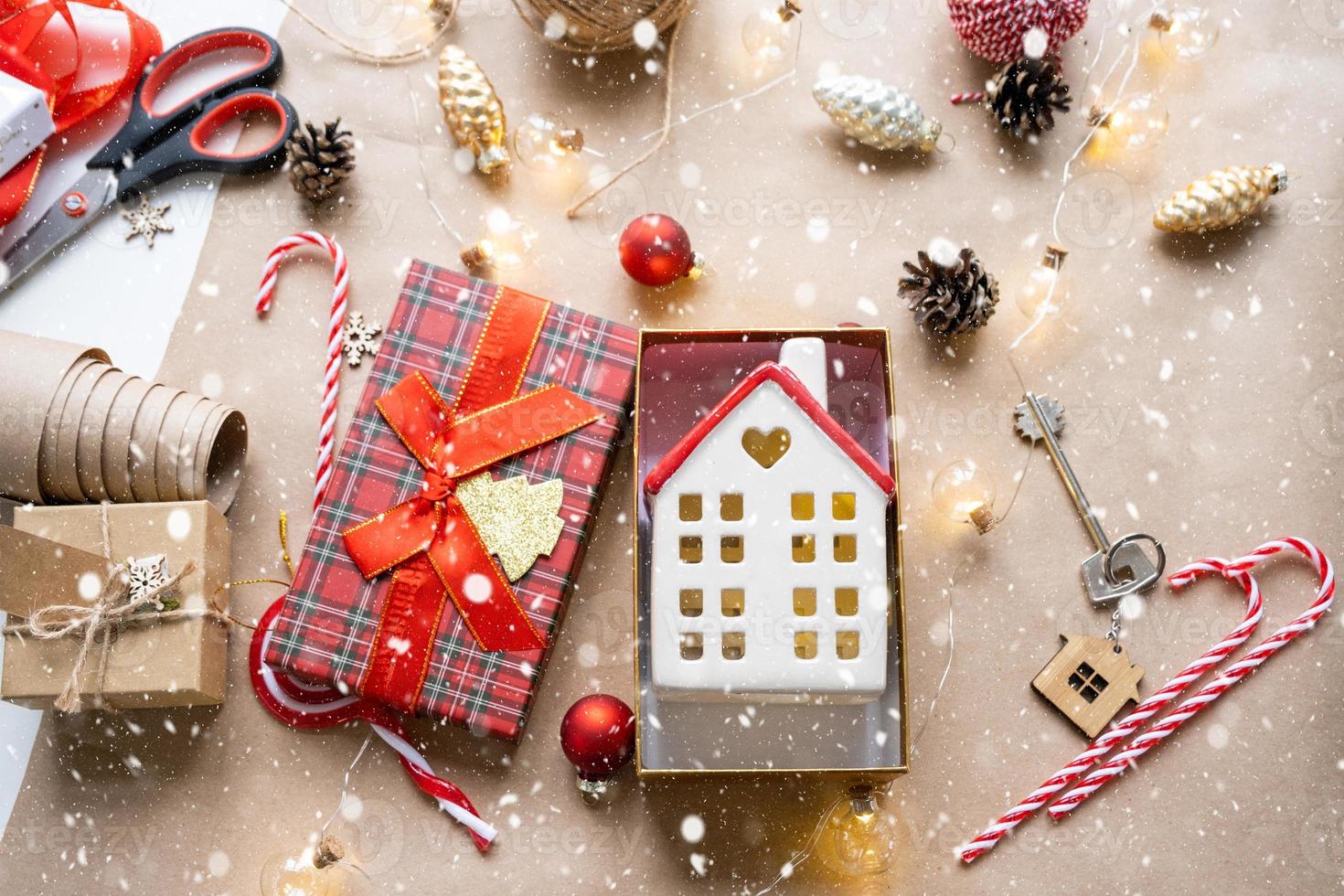 schlüssel zum haus mit schlüsselbund auf gemütlichem zuhause in geschenkbox mit weihnachtsdekorverpackung. pack geschenk für neujahr, weihnachten. Bauen, Projekt, Umzug in ein neues Haus, Hypothek, Miete, Kauf von Immobilien foto