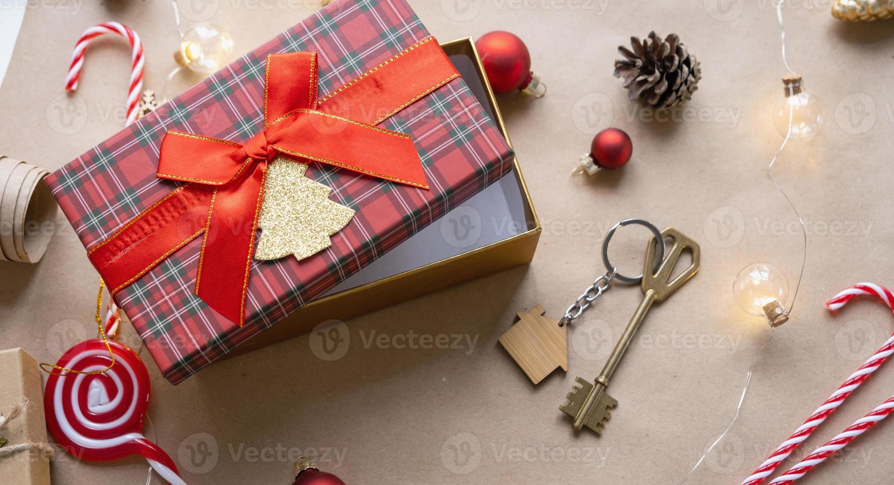 schlüssel zum haus mit schlüsselbund auf gemütlichem zuhause in geschenkbox mit weihnachtsdekorverpackung. pack geschenk für neujahr, weihnachten. Bauen, Projekt, Umzug in ein neues Haus, Hypothek, Miete, Kauf von Immobilien foto