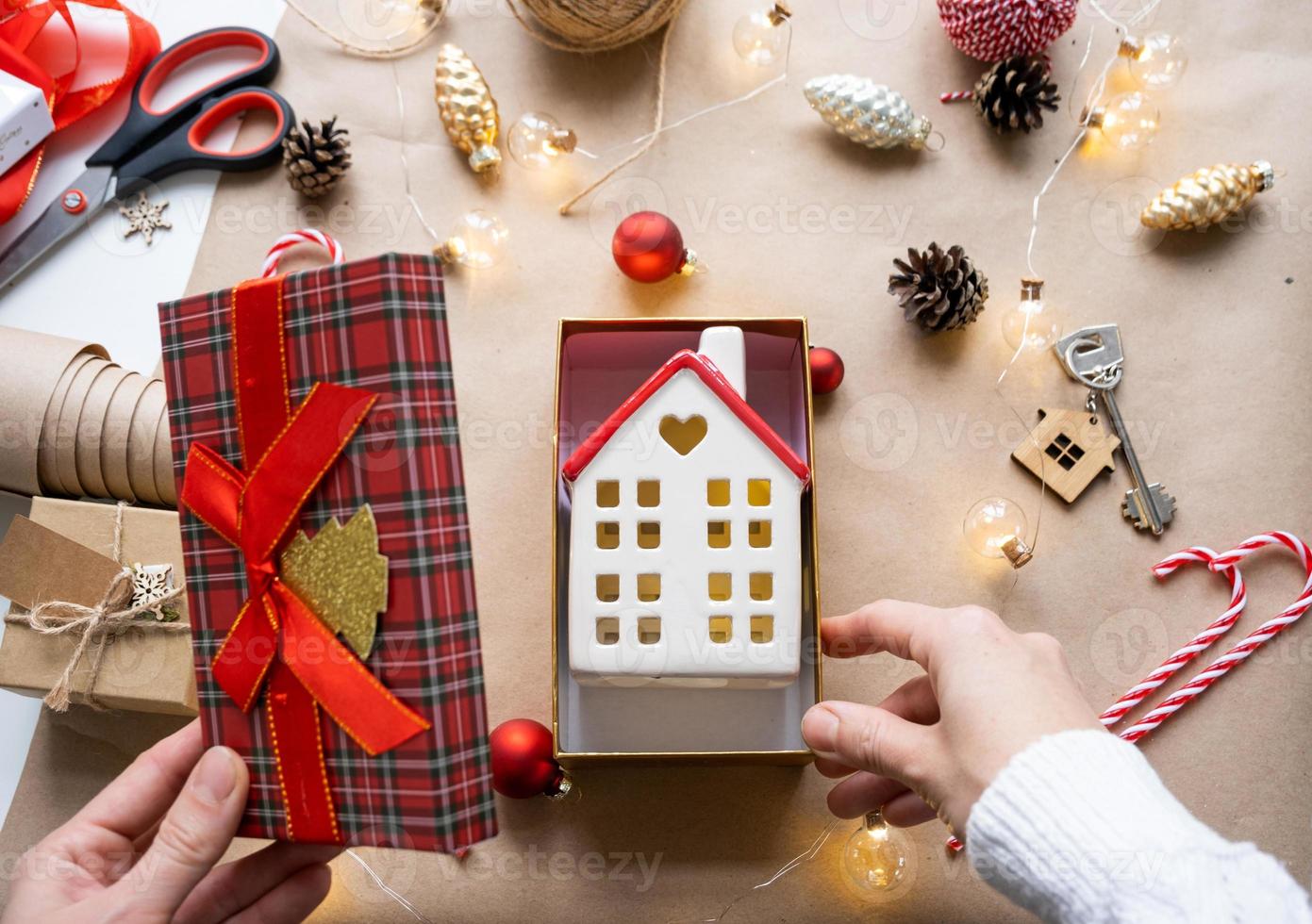 schlüssel zum haus mit schlüsselbund auf gemütlichem zuhause in geschenkbox mit weihnachtsdekorverpackung. pack geschenk für neujahr, weihnachten. Bauen, Projekt, Umzug in ein neues Haus, Hypothek, Miete, Kauf von Immobilien foto