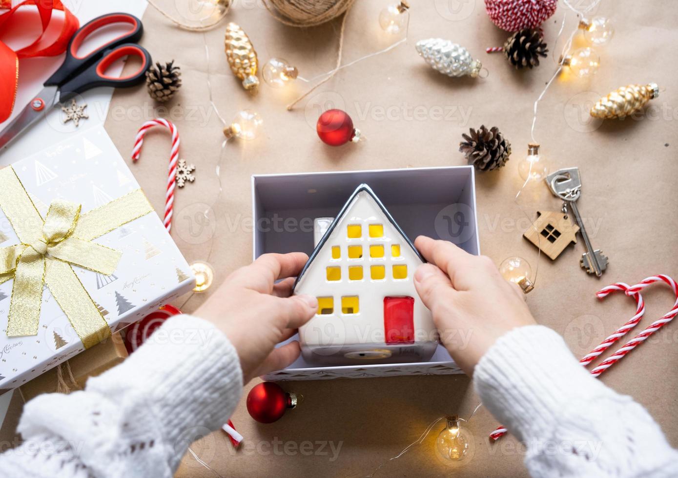 schlüssel zum haus mit schlüsselbund auf gemütlichem zuhause in geschenkbox mit weihnachtsdekorverpackung. pack geschenk für neujahr, weihnachten. Bauen, Projekt, Umzug in ein neues Haus, Hypothek, Miete, Kauf von Immobilien foto