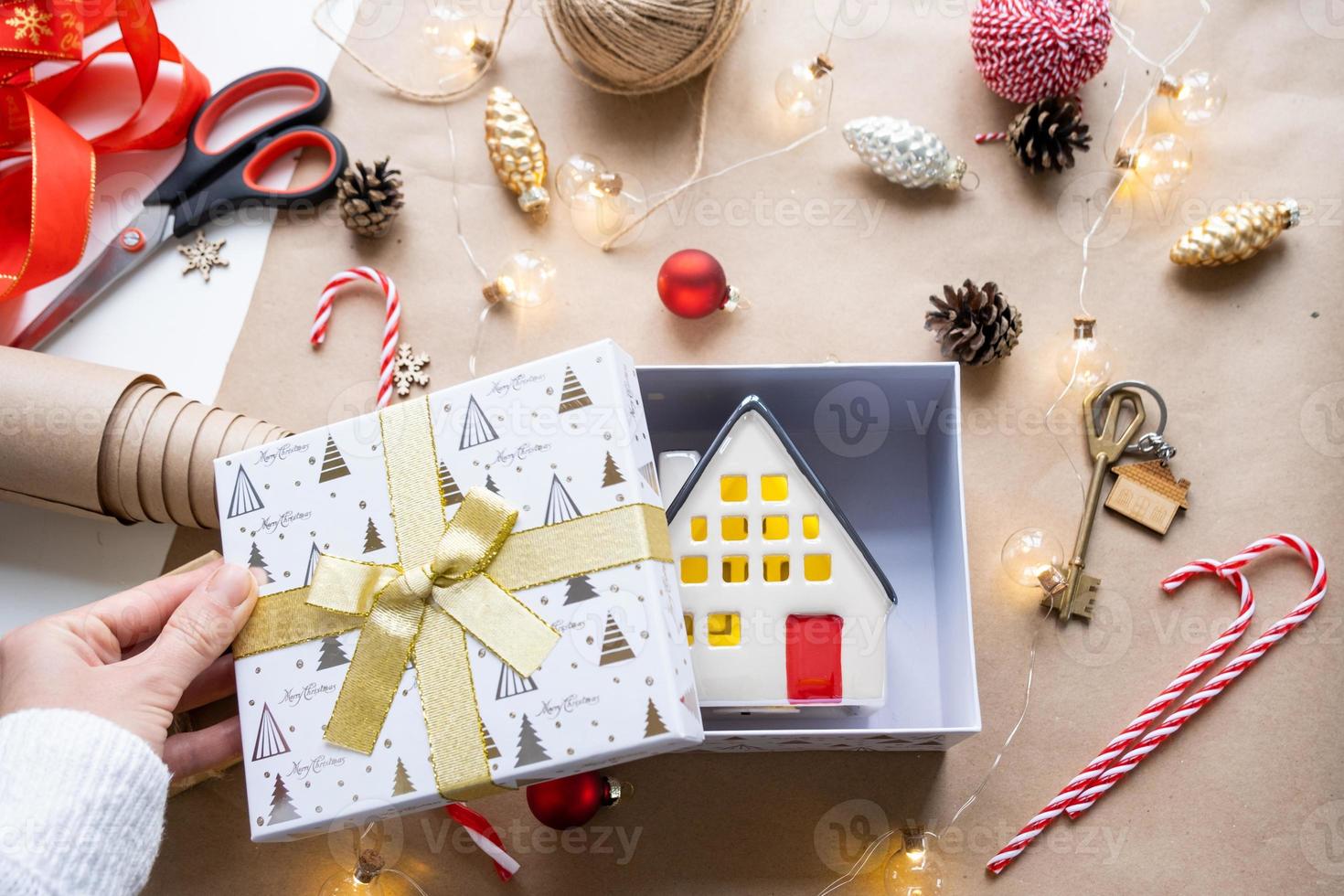 schlüssel zum haus mit schlüsselbund auf gemütlichem zuhause in geschenkbox mit weihnachtsdekorverpackung. pack geschenk für neujahr, weihnachten. Bauen, Projekt, Umzug in ein neues Haus, Hypothek, Miete, Kauf von Immobilien foto