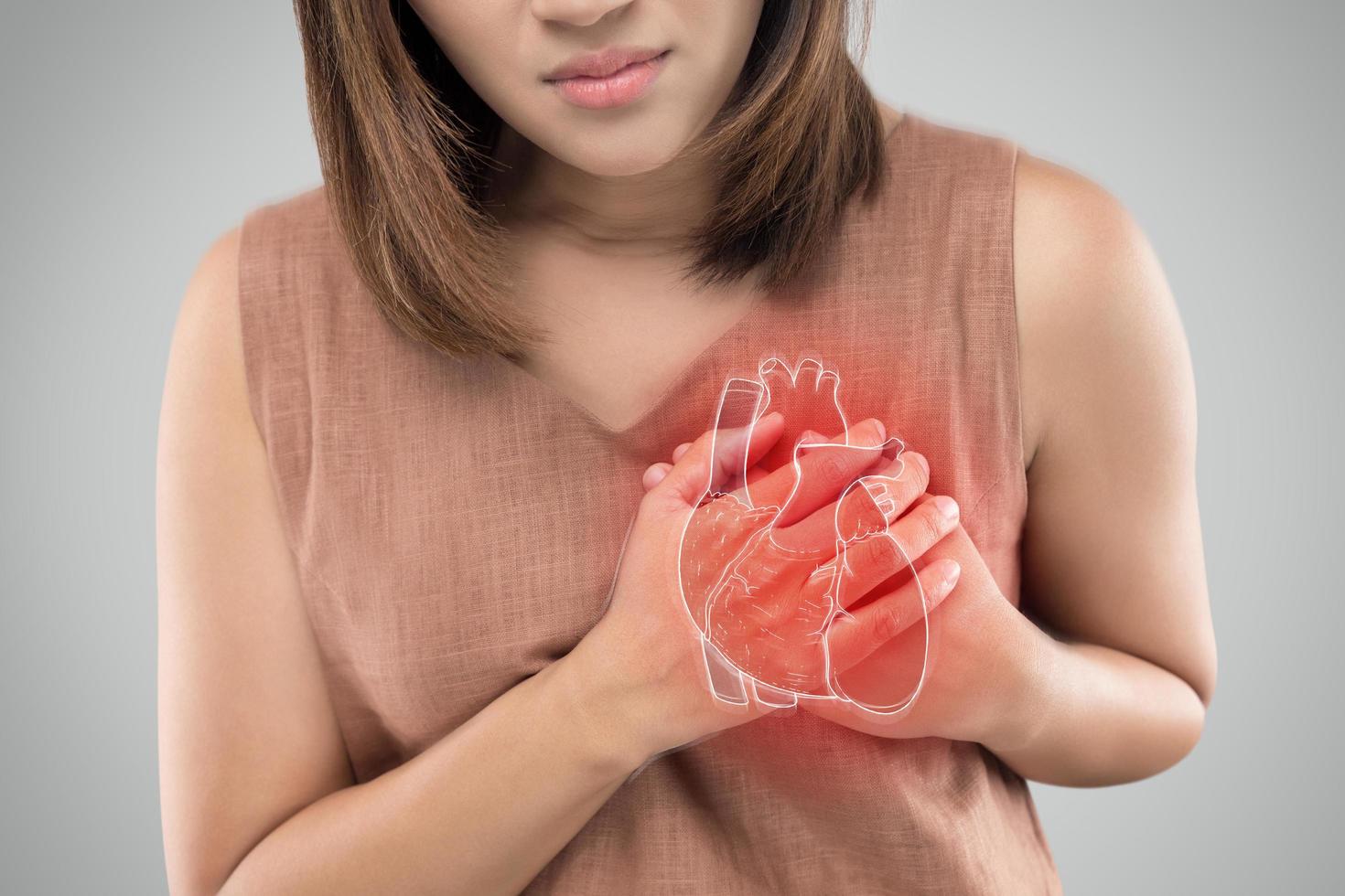 Das Foto des Herzens befindet sich auf dem Körper der Frau, schwerer Herzschmerz, Herzinfarkt oder schmerzhafte Krämpfe, Herzkrankheit, Drücken auf die Brust mit schmerzhaftem Ausdruck.