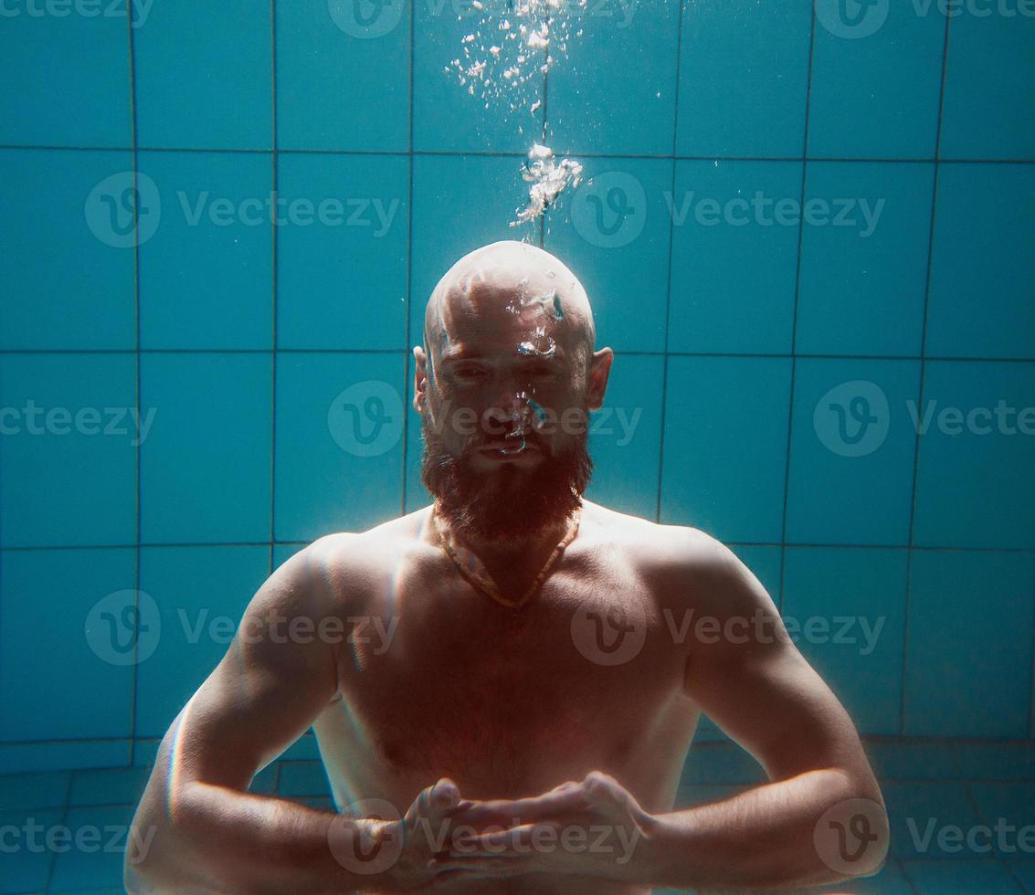 athletischer sportmann unter wasser im schwimmbad. Sport, Yoga, Freitauchkonzept foto