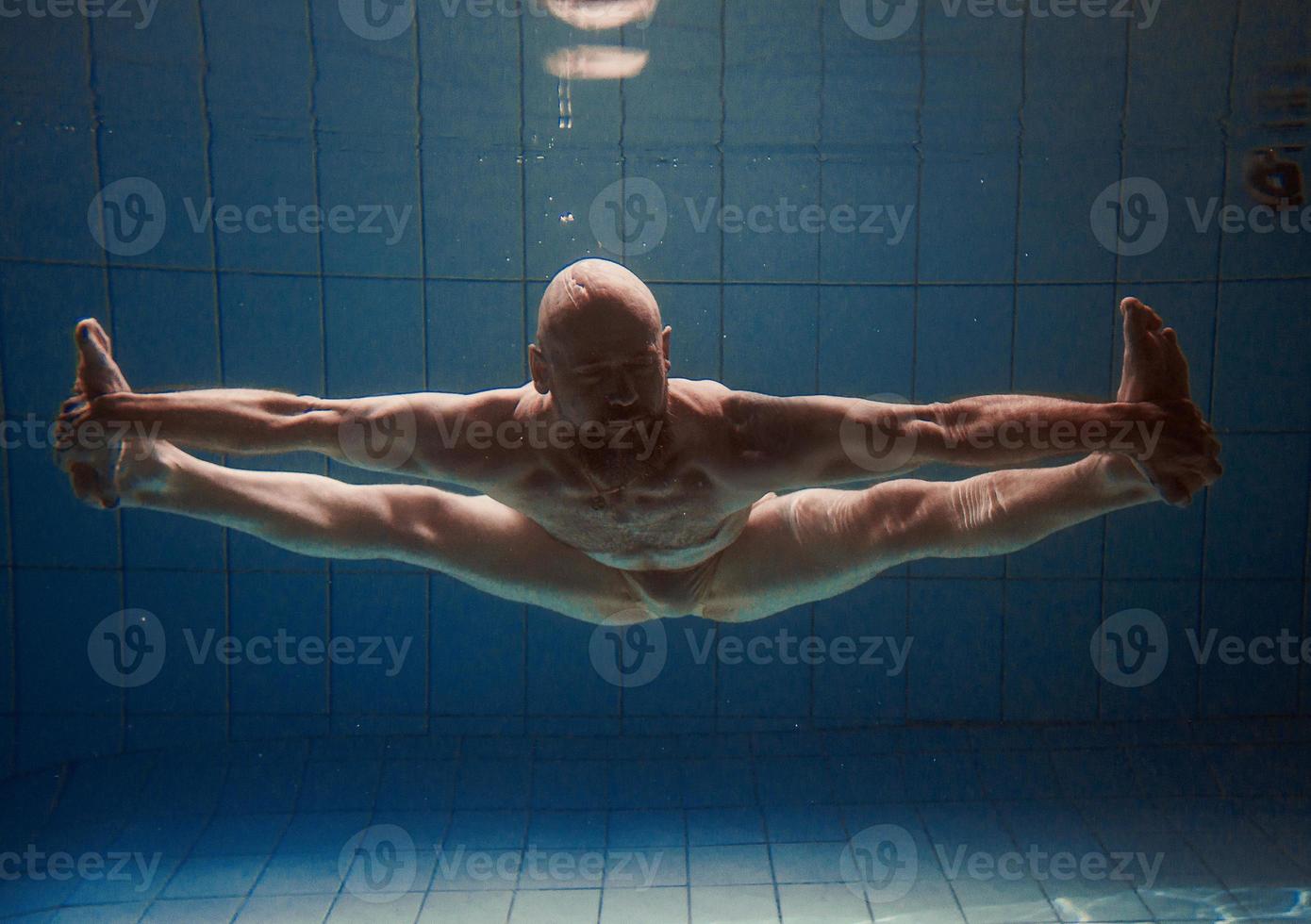 athletischer sportmann unter wasser im schwimmbad. Sport, Yoga, Freitauchkonzept foto