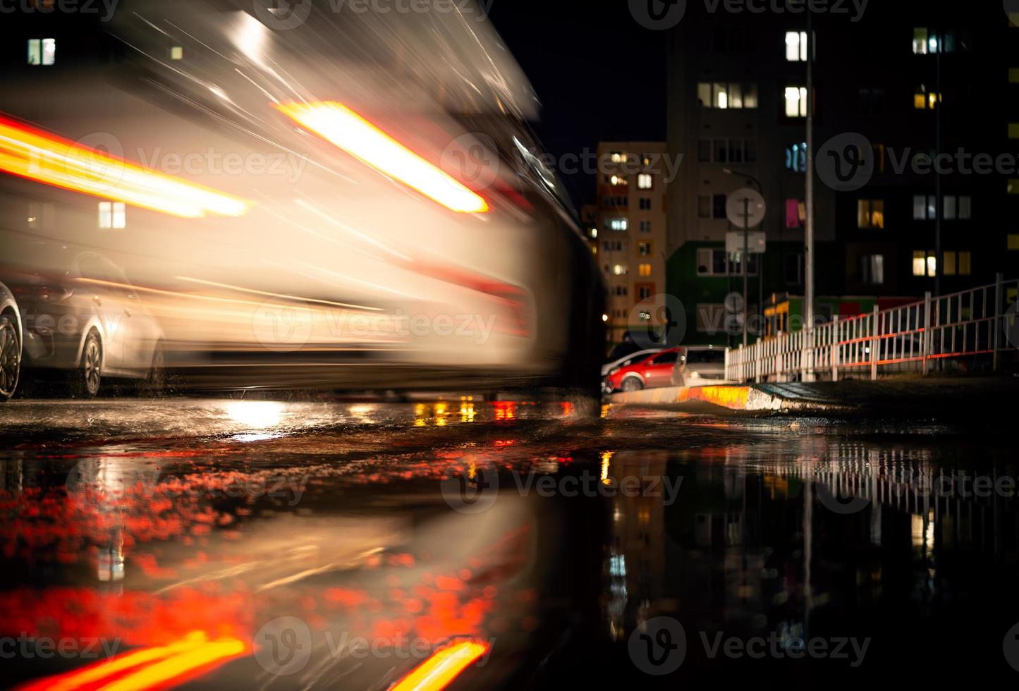 Ein weißes Auto auf der Straße mit unscharfem Verkehrshintergrund. foto