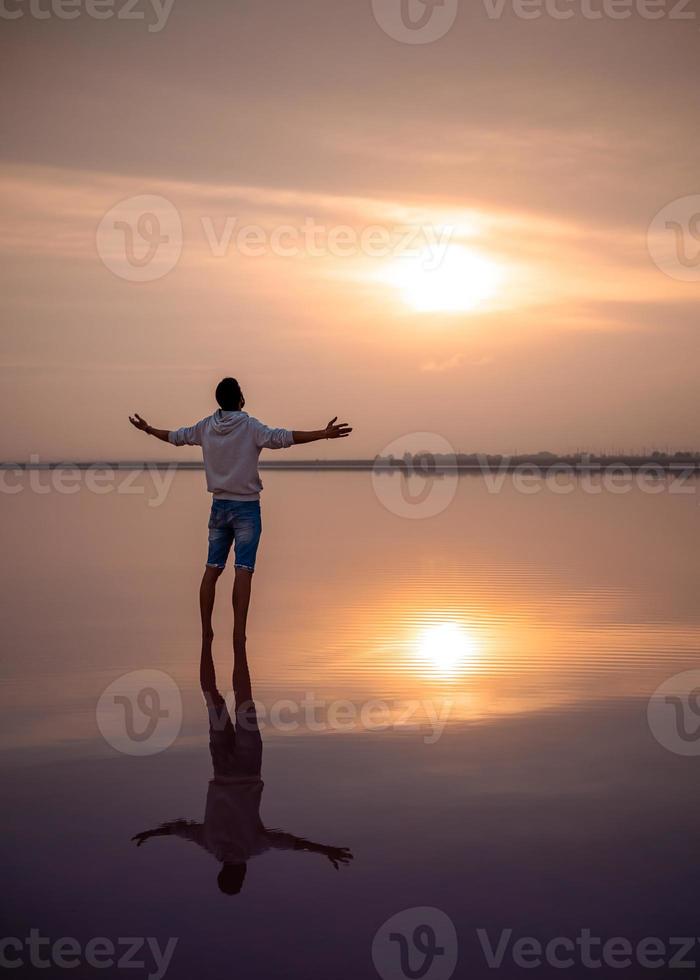 männliche Silhouette am Strand. ein Spaziergang in der Morgendämmerung und Meditation. foto