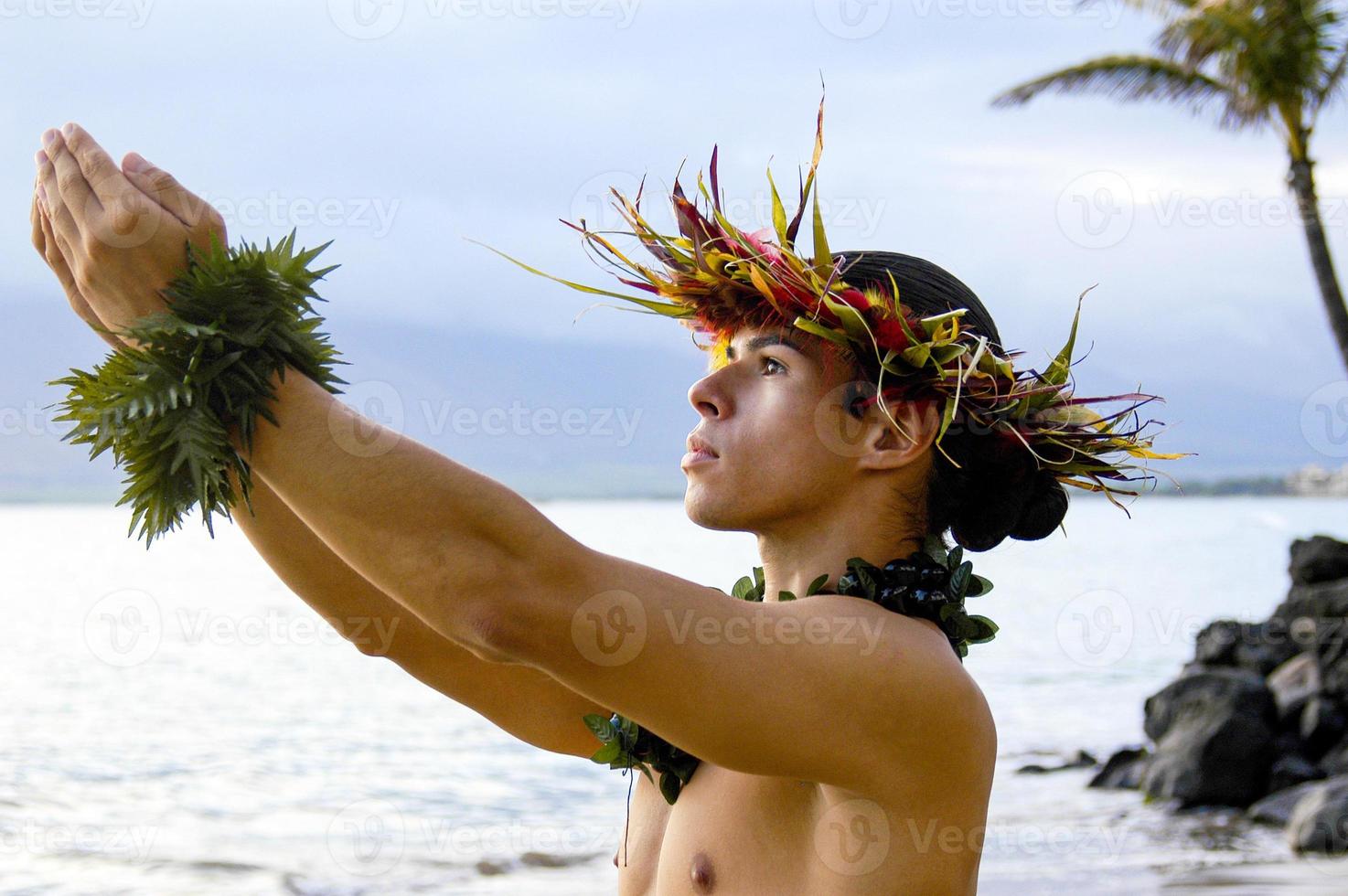 männlicher Hula-Tänzer tritt am Strand mit ausdrucksstarken betenden Handbewegungen auf. foto