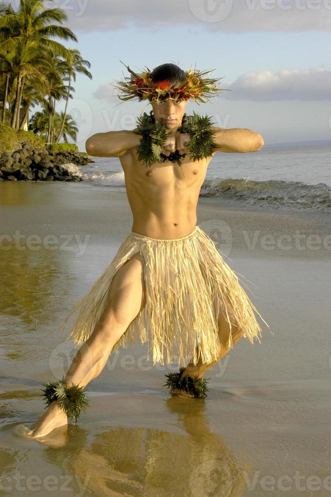 Hawaiianischer männlicher Hula-Tänzer trifft eine Krafthaltung am Strand in Maui, Hawaii. foto