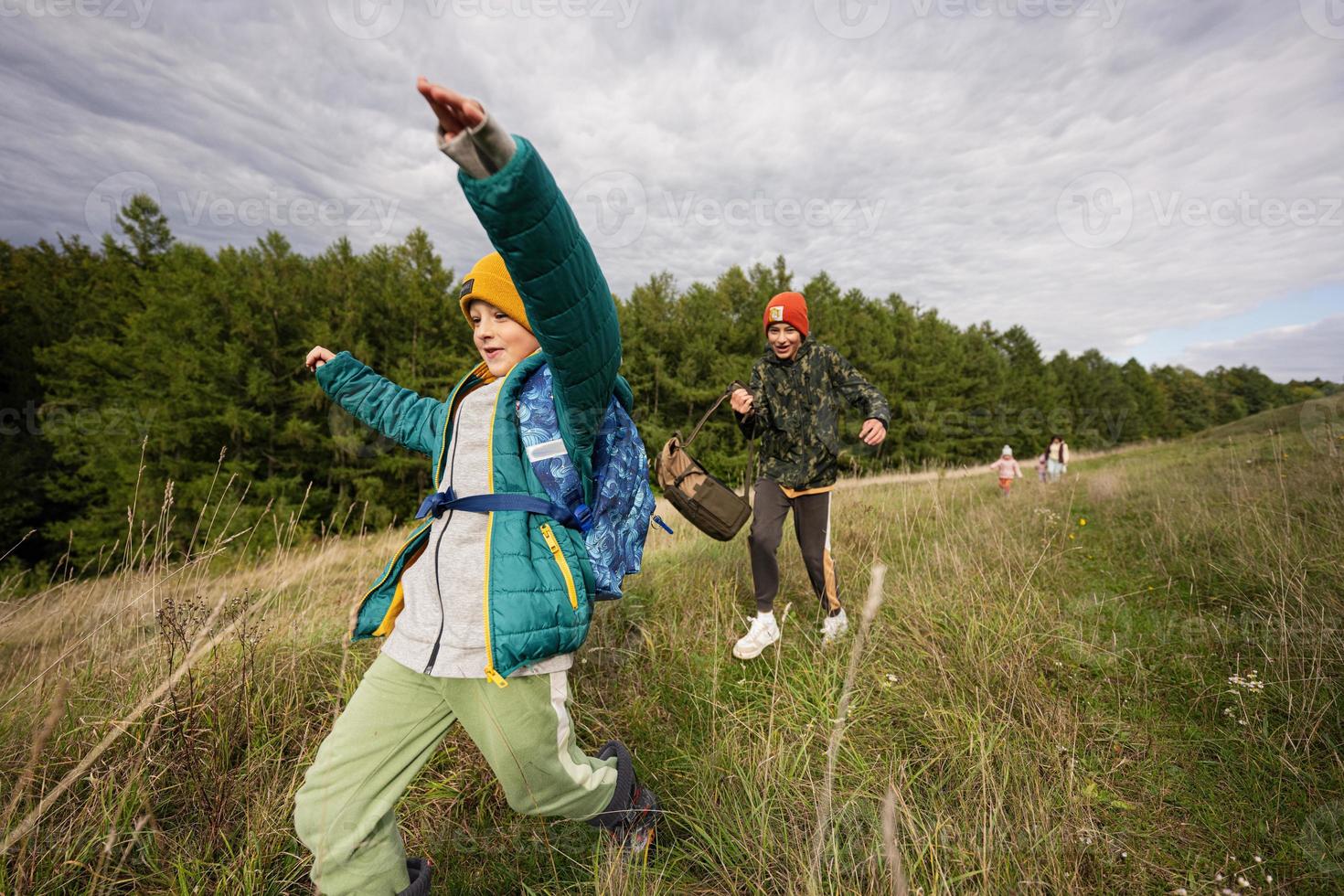 brüder haben spaß und laufen im freien in der nähe des waldes. foto