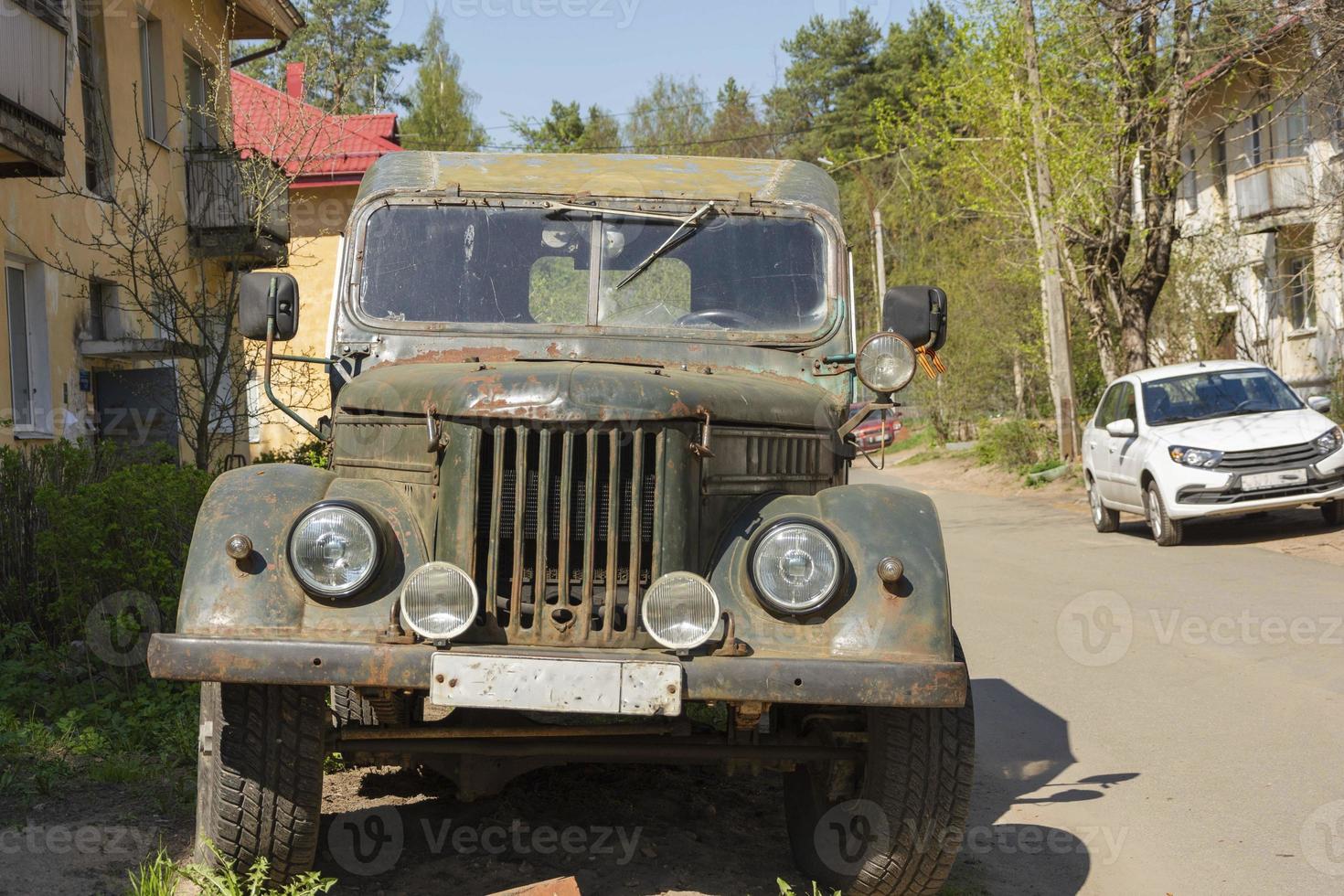 alter ramponierter militärjeep verlassen auf der straße im hof, militärische ausrüstung, suv, traktor foto