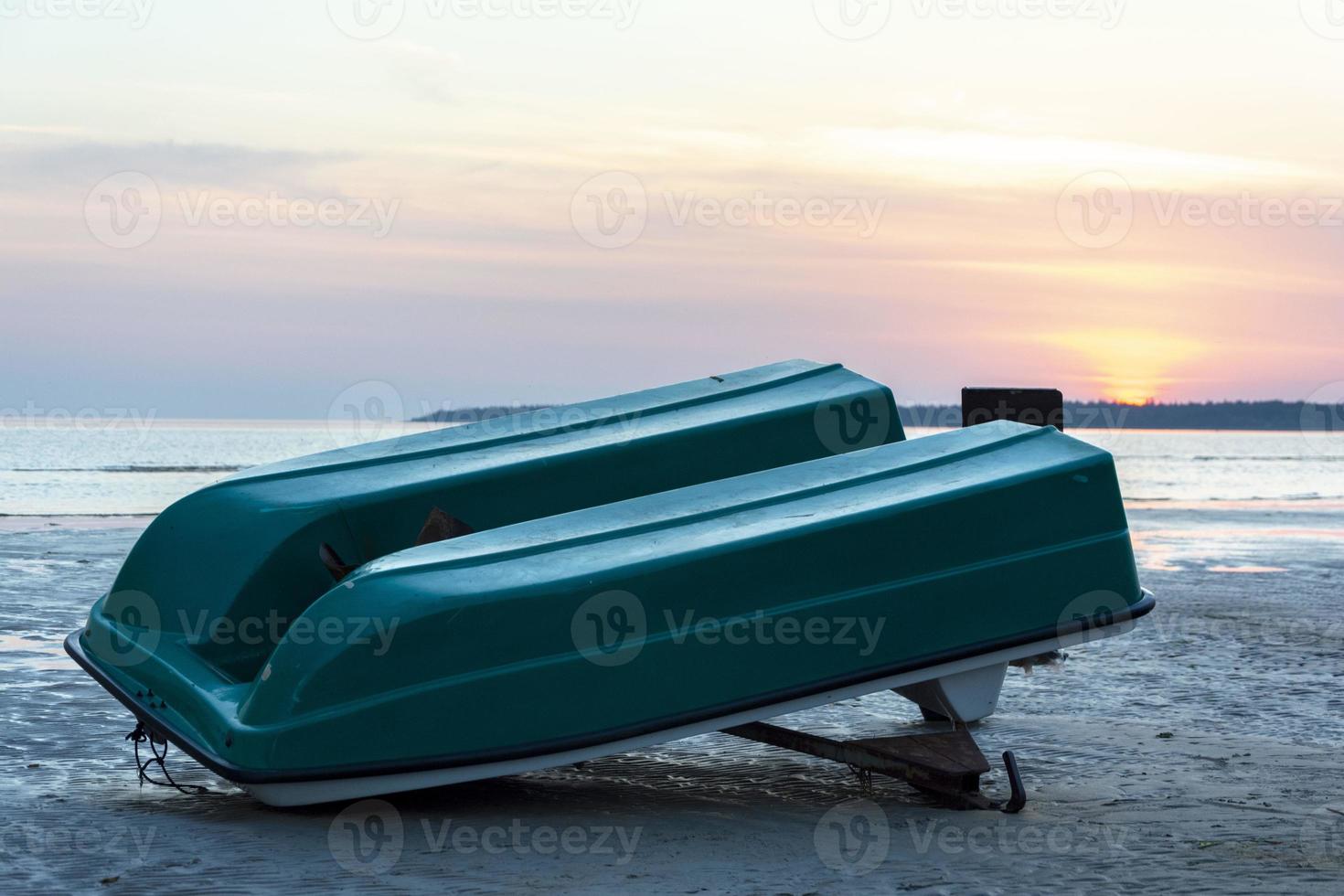 ein altes umgekehrtes Plastikboot am Ufer der Meeresbucht, ein alter Katamaran, ein Propeller foto