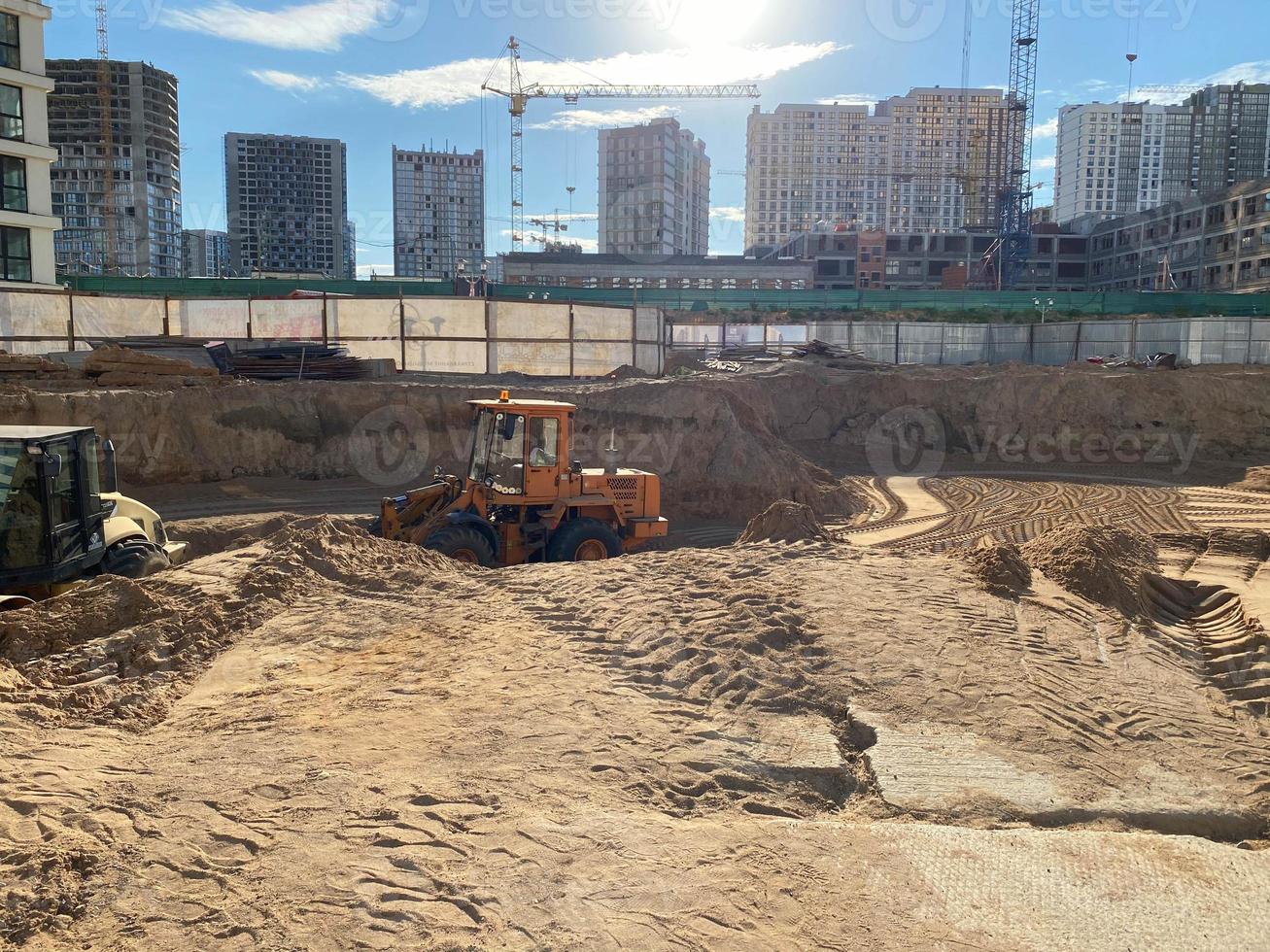 eine große baustelle von neuen hohen großen häusern aus monolithischen betongebäuden mit kränen und baugeräten während der reparatur neuer gebäude in einer großen dicht besiedelten stadt foto