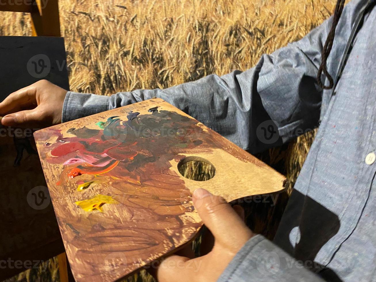 Künstler Pinsel Mix Farbe Ölgemälde auf Palette hält in seiner Hand Nahaufnahme foto