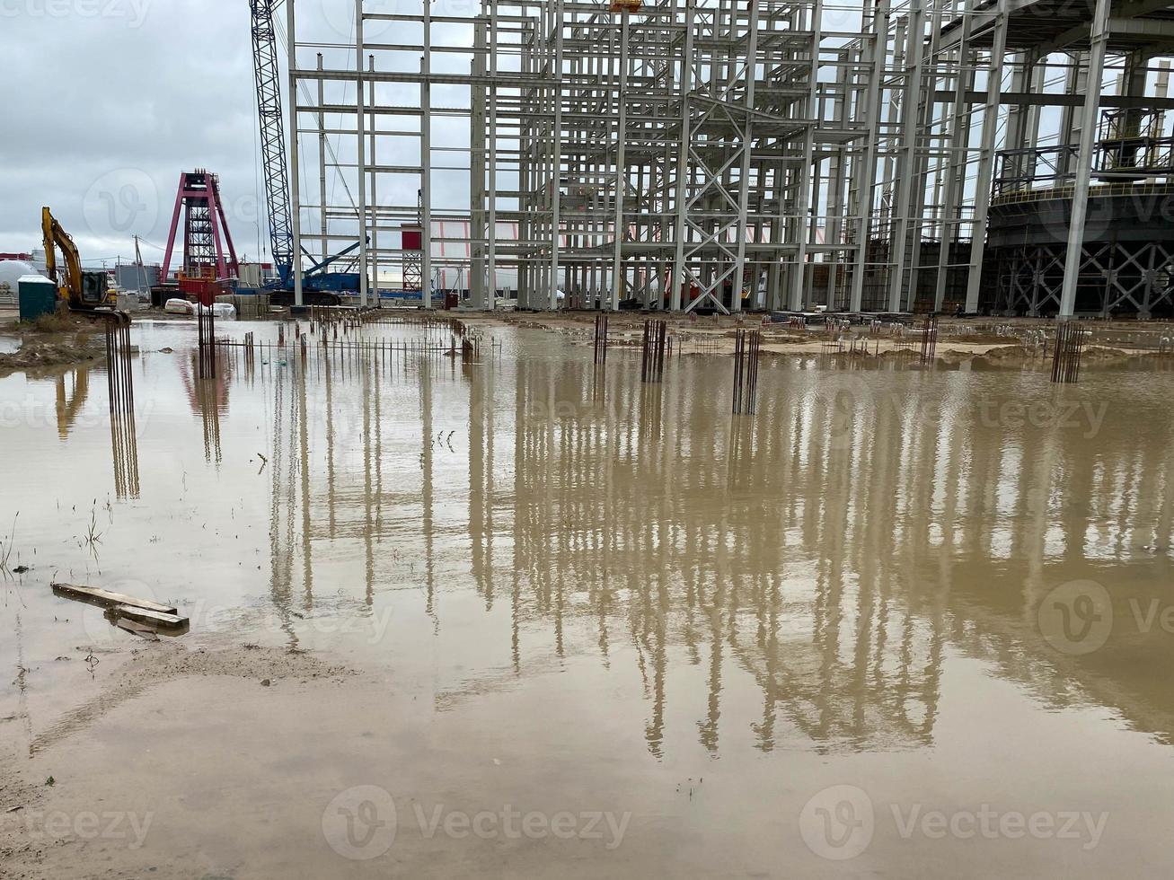 Lagergebäude aus Stahlkonstruktion. Industriegebäude auf leichtem Stahlrahmen. Rahmen eines modernen Hangars oder einer Fabrik. LKW-Kran auf der Baustelle während der Montage der Metallstruktur foto