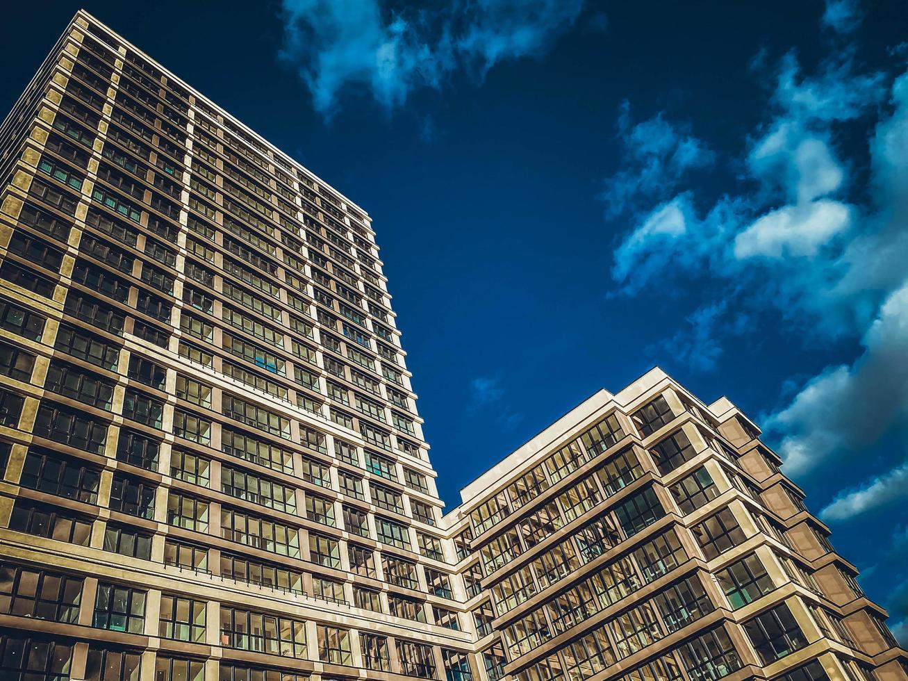 Zwei große große neue Wohngebäude Wolkenkratzergebäude, die mit monolithischer Rahmenkonstruktionstechnologie vor dem Hintergrund eines blauen Himmels gebaut wurden foto