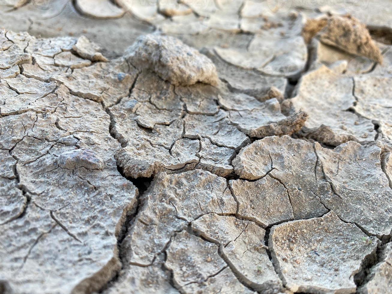 Graue, trockene, rissige, schöne Textur aus trockenem Boden und Wüstenlehm. der Hintergrund foto