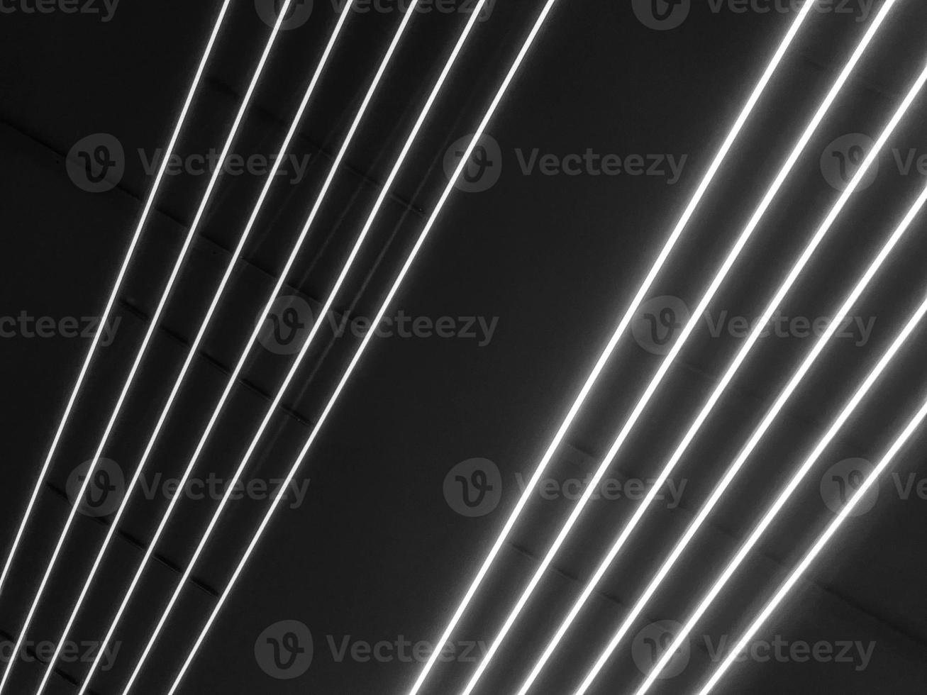 textur von schwarz-weiß leuchtenden hellen neon-led-mehrfarbigen laser-abstrakten streifen und linien von parallelen lampen. der Hintergrund foto