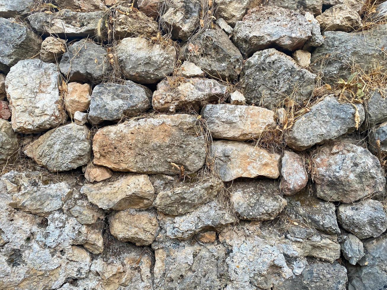hintergrund, textur, steinmauer aus runden steinen kopfsteinpflaster ziegel natürliche oberfläche natürliche scharfe konvexe raue steinpflastersteine mit rissen foto