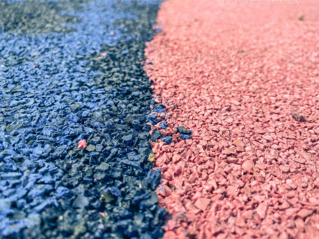 Beschichtung für einen Sportplatz, rutschfester Boden. blau-rosa Textur, Steine in verschiedenen Farben. Hintergrund aus kleinen, rosa und blauen Steinen, die dicht an dicht auf der Straße liegen foto