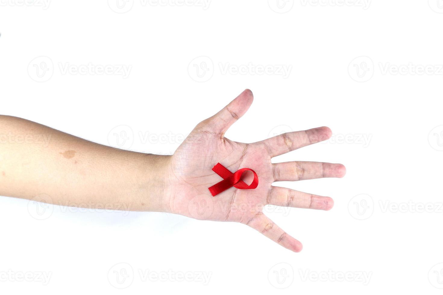 Handsymbol mit rotem Band, das die Sorge um Menschen mit HIV-Aids symbolisiert, die auf weißem Hintergrund isoliert sind foto