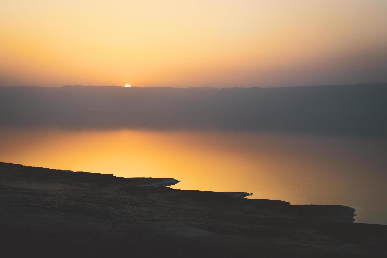 Totes Meer Landschaft, Versagen des Bodens, Veranschaulichung einer Umweltkatastrophe des Toten Meeres. Salzkristalle bei Sonnenuntergang. Textur des Toten Meeres. salzige Küste foto