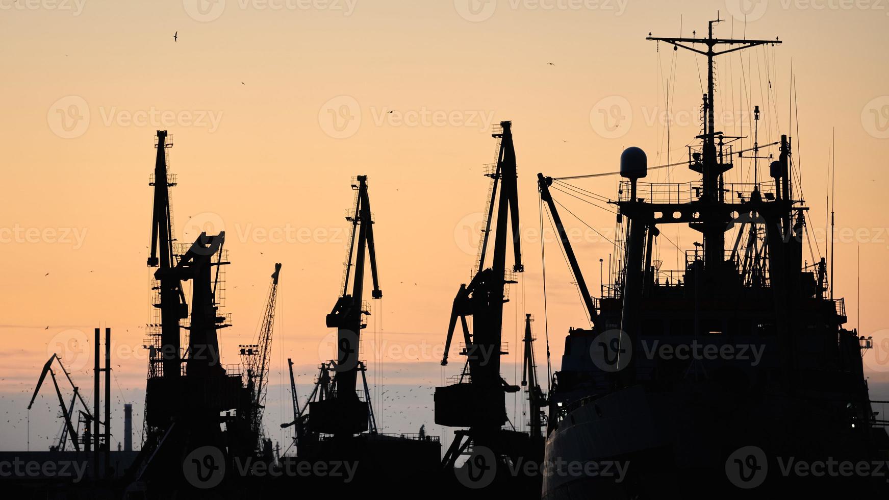 Silhouetten von Schiffen und Containerkränen im Seehafen foto